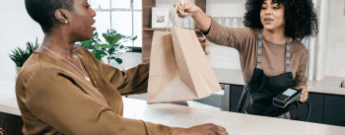 Retail clerk handing a customer a shopping bag