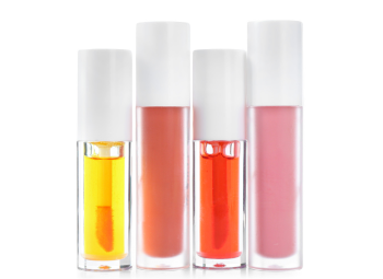 Four different colored lip glosses next to each other.