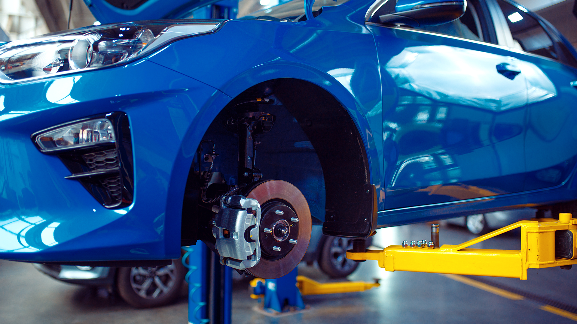 blue car on a lift receiving service