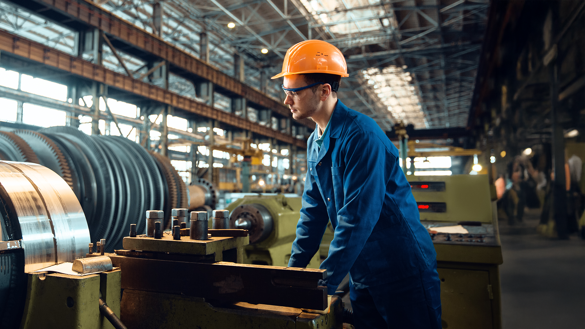 male worker in a warehouse checking lathe