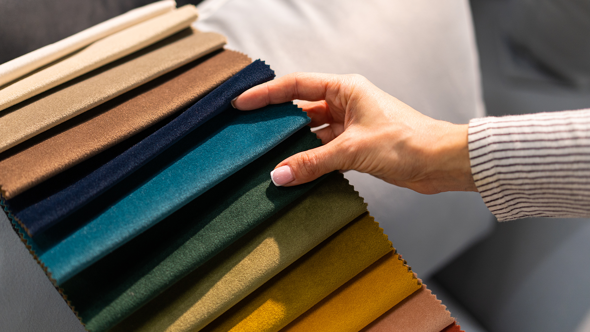 woman's hand touching textile sofa samples
